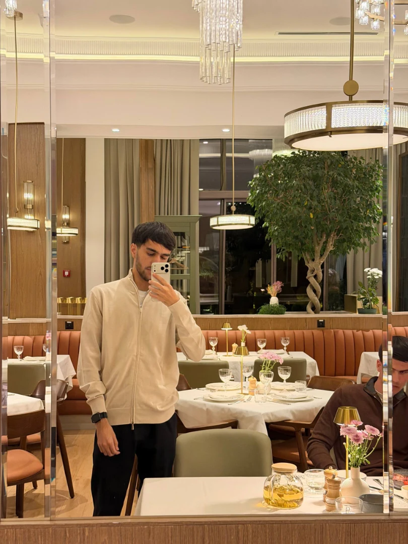 Sarvarmirzo Nurullaev taking a mirror portrait in a restaurant